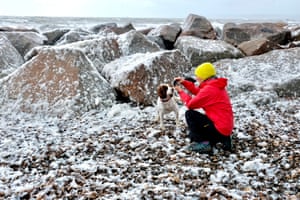 Dorset: Os visitantes experimentaram condições incomuns na costa jurássica de Dorset em maio, quando ventos excepcionalmente fortes combinados com uma maré alta para produzir espuma, que soprou através do resort de férias de West Bay.