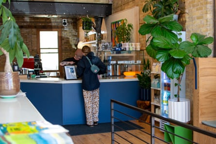 a person standing at a counter in a coffee shop