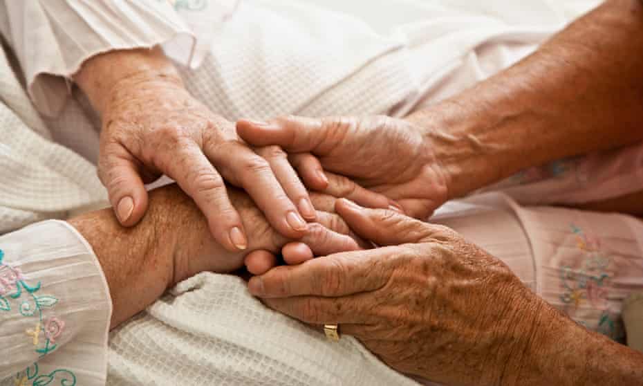 Two elderly people holding hands