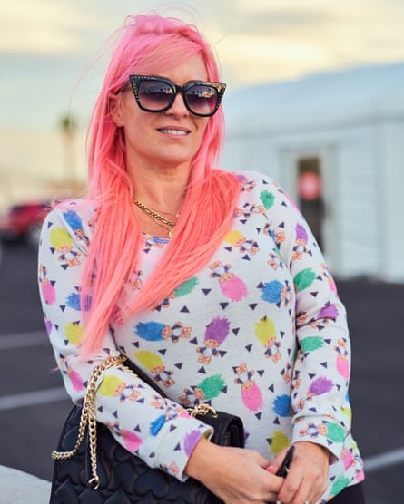 Woman with pink hair wearing big sunglasses and colorful sweater