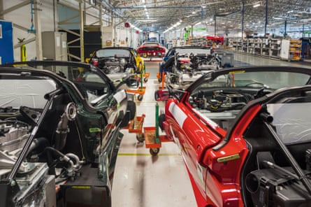 Lotus sports cars, still without roofs or rear windows, viewed from behind on the assembly line at Hethel.