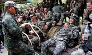 South Korean and US Marines listen to an instructor tell them how to catch a snake during a joint military exercise
