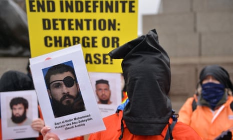 A protester wearing a black hood holds a portrait of detainee Abu Zubaydah during a demonstration in London on Saturday.