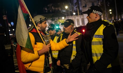 Filistin yanlısı bir protestocu polisle konuşuyor.