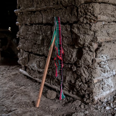 A child's stick rests against the wall of his house