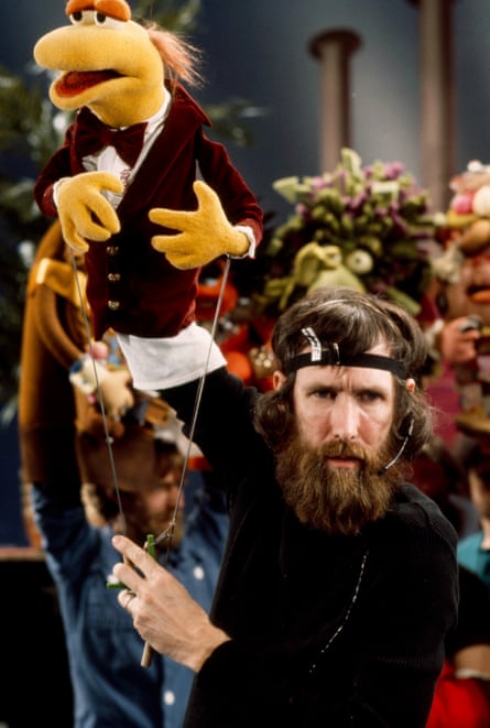The puppeteer, with long hair and beard, controlling a Muppet on set