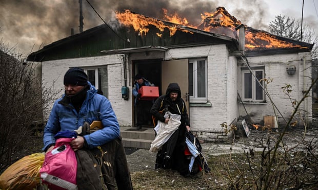 People flee a burning house after being shelled in the city of Irpin, outside Kyiv, on 4 March.