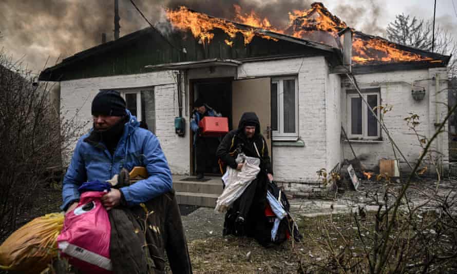 People remove personal belongings from a burning house after being shelled in the city of Irpin, outside Kyiv.