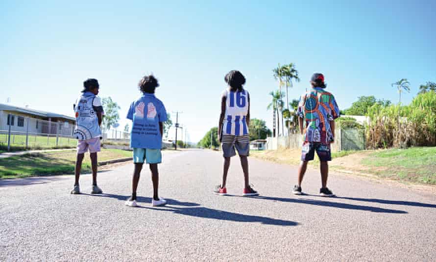 Four boys stand on a road in the Northern Territory, Australia