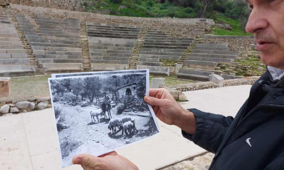 A member of Prof Lambrinoudakis’ team showing a picture of farmer Christos Zafiris, the site’s former owner, on the spot where the Little Theatre of Epidavros was discovered.