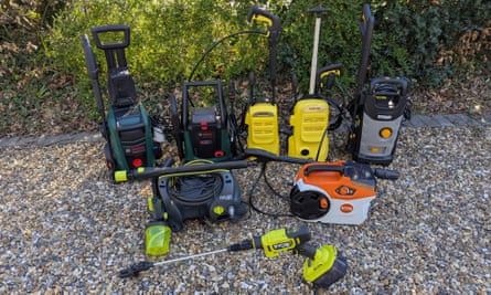 Eight pressure washers on a gravel driveway