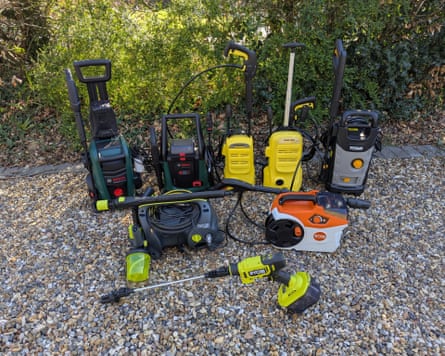 Eight pressure washers on a gravel driveway