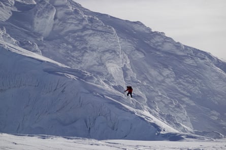 A walker ascends a snowy incline