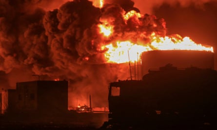 Smoke and flames surround oil tanks
