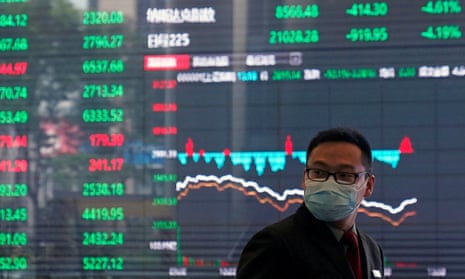 A man wearing a protective mask is seen inside the Shanghai stock exchange building