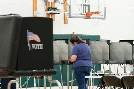 A person fills in a ballot at a voting booth during early voting for midterm elections