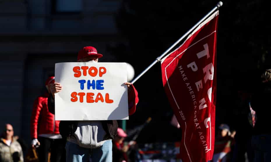 A Trump supporter holds a ‘Stop the Steal’ sign in Denver, Colorado, on 6 January. 