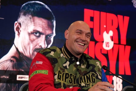 Tyson Fury smiles at a press conference to promote his fight against Oleksandr Usyk.