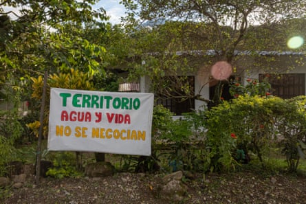 A hand-painted sign attached to a garden fence reads ‘Territory, water and life are non-negotiable’ in Spanish