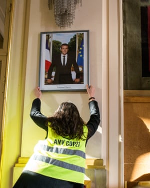Macron’s portrait being taken down.