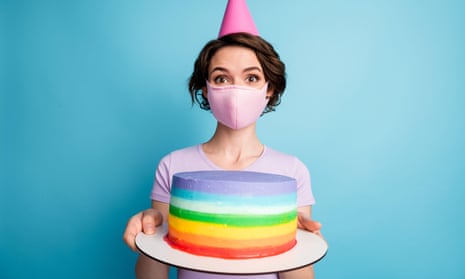 Girl in medical mask holding a multicoloured cake