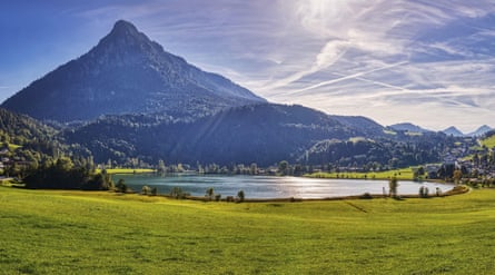 A lake with a pointed, wooded mountain behind