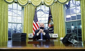 Biden signs executive orders in the Oval Office.