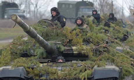 Members of the Ukrainian armed forces drive a tank during military drills