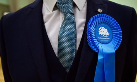 A man wearing a Conservative party rosette