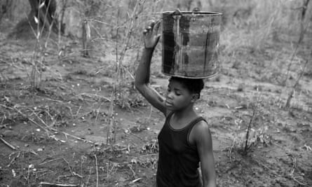 Josefina Fabiao, 12, carries water home from the Rio Naranja