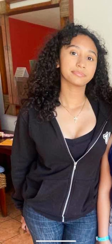 A teenage girl in a black hoodie.