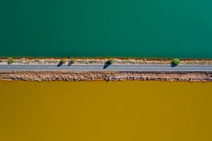 A narrow strip of road divides ochre-coloured and fresh waters, Río Tinto, Huelva, Spain