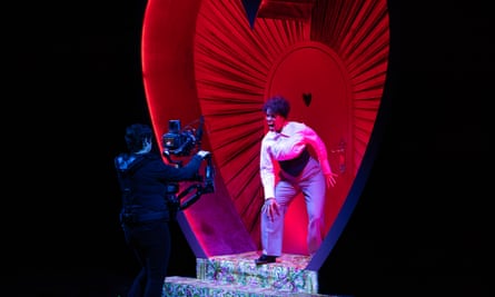 An actor onstage baring their teeth in front of a camera operator