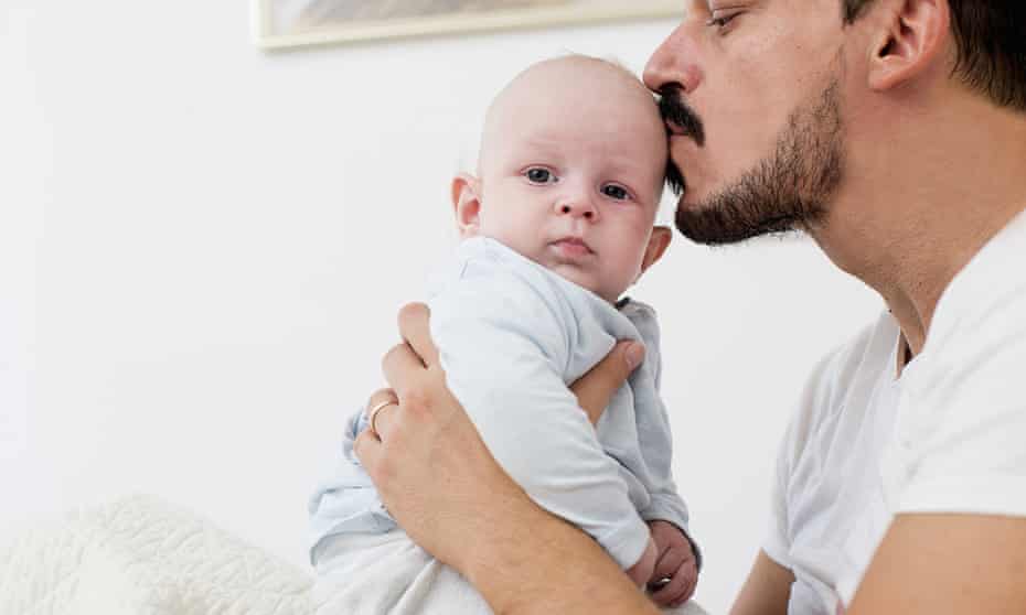 Dad kissing baby tenderly