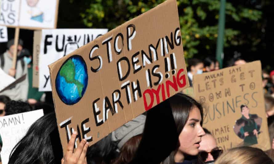 A protester holds a 'stop denying, the Earth is dying' placard at a climate change rally in Melbourne