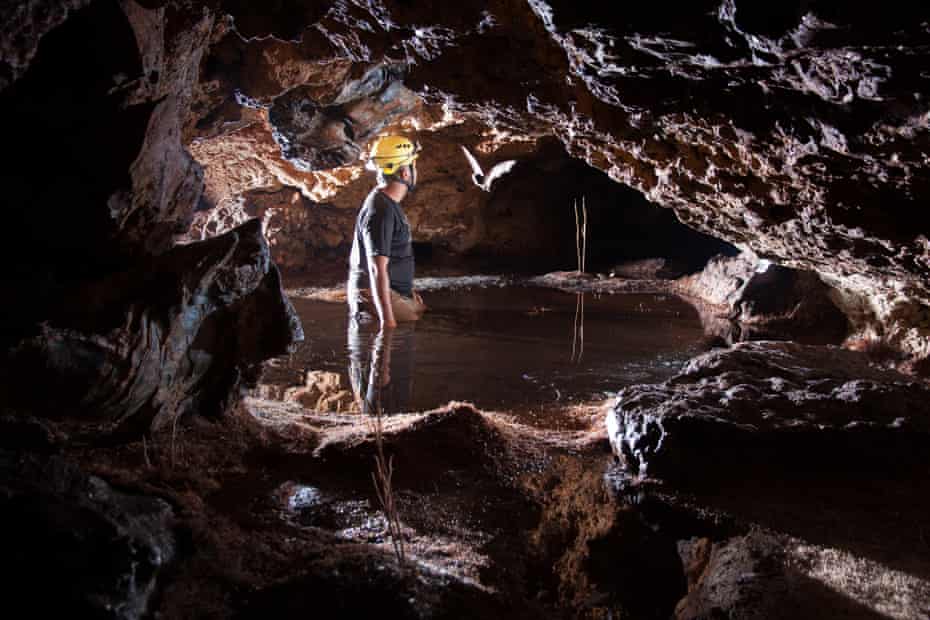 a scientist explores a partially flooded ironstone cave in Vale do Rio Peixe Bravo River, northern Minas Gerais State, Brazil