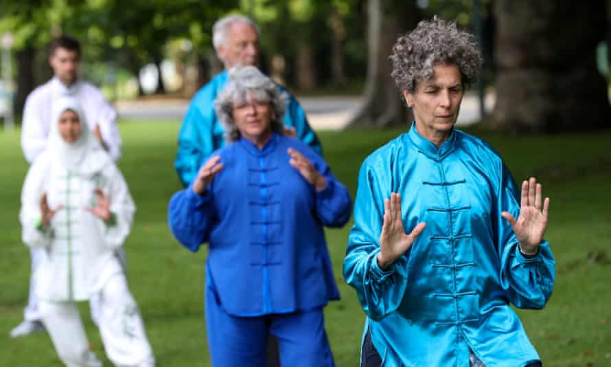 People practice Tai Chi in a park