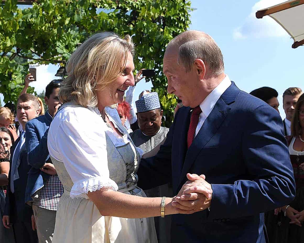Karin Kneissl dancing with Putin outdoors with people in background