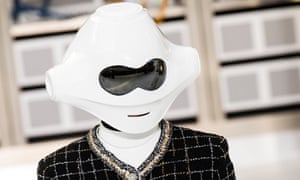 A Chanel model wearing a white plastic robot mask