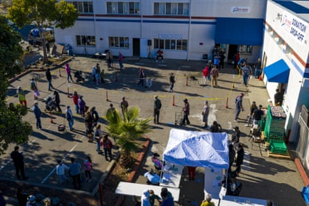 Aerial shot of the long line of people snaking around a parking lot that serves as a food distribution site.