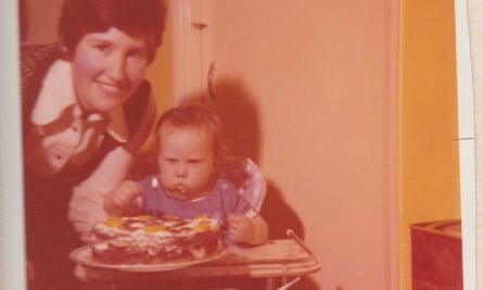 Matt as a toddler in a high chair eating, with his mother