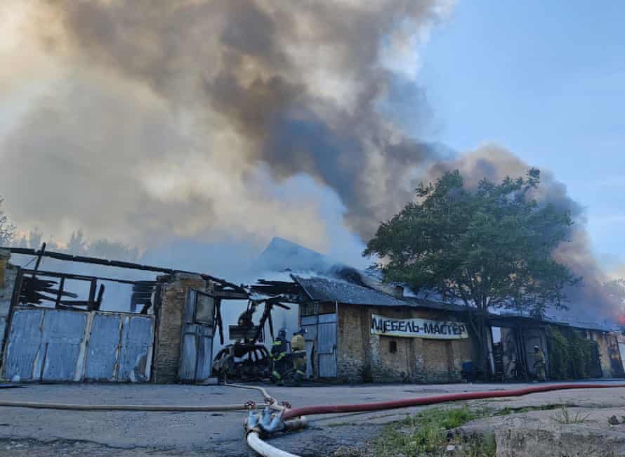 Firefighters extinguish a fire at a warehouse following recent shelling in Donetsk.