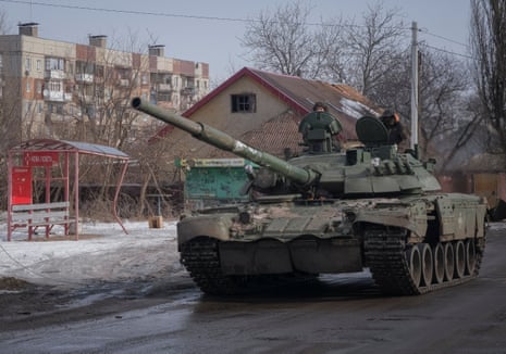 Ukrainian service members ride a tank in the frontline city of Bakhmut.