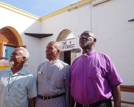 Bishop Brooks, Rev Wycherley Gumbs and Father Hodge in their now roofless Methodist church