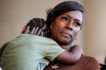 A middle-aged woman with a small child in her arms.
