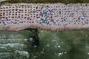 A crowded beach and swimmers in the sea