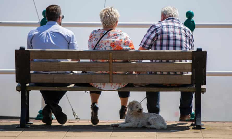 Penarth, Wales. A dog enjoys the shade of a bench on the esplanade.