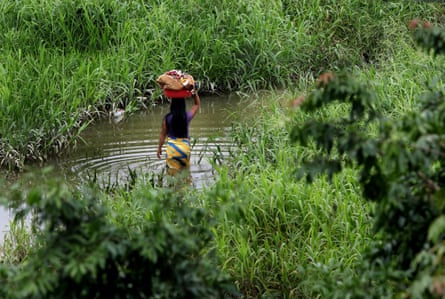 A woman carries her laundry in the Atrato river, Colombia, which has been recognised as a legal entity.
