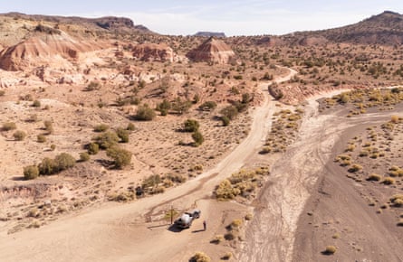 Drone shot of man by a car in an arid landscape