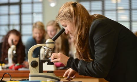 Female student looking down microscope